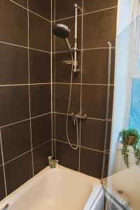 a bathroom with a shower with a tub at 1 bedroom flat with easy parking/public transport in Dundee