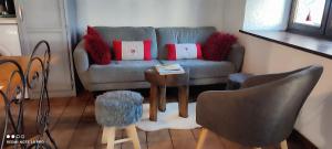 ein Wohnzimmer mit einem Sofa und einem Tisch in der Unterkunft LA RUSTIQUE DU BOUT DU LAC in Chambon-sur-Lac