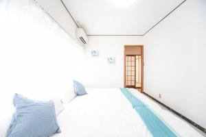 a bedroom with a white bed with blue pillows at Yokkaichi - House - Vacation STAY 68949v in Yokkaichi