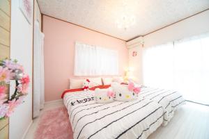 un dormitorio con una cama con almohadas de hola kitty en Yokkaichi City - House - Vacation STAY 68977v en Nishi-hino