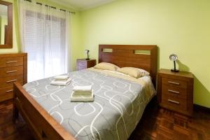 Eixo的住宿－Aveiro Cozy Apartment，一间卧室配有一张大床和两条毛巾