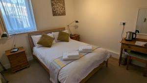 a bedroom with a bed with towels on it at Ivybridge Guesthouse in Fishguard
