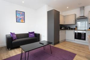 a living room with a couch and a table at Pillo Rooms Serviced Apartments - Manchester Arena in Manchester