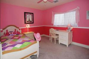 1 dormitorio con paredes rosas, 1 cama y escritorio en Enjoy Vacation in a Quiet Area with Huge Backyard, en Crosby