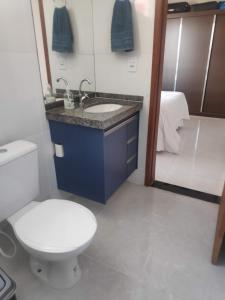 a bathroom with a toilet and a sink and a shower at Apartamento Ar condicionado, varanda, 2 vagas garagem in Muriaé