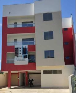 a building with a motorcycle parked in front of it at Apartamento Ar condicionado, varanda, 2 vagas garagem in Muriaé