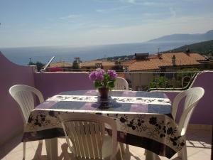 a table with a vase of flowers on a balcony at Casa Purple in Cala Gonone