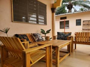 a patio with a wooden table and chairs at Maison fleurie Ouidah in Ouidah