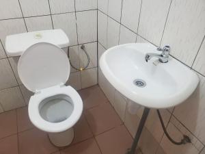 a bathroom with a white toilet and a sink at Maison fleurie Ouidah in Ouidah +6 photos