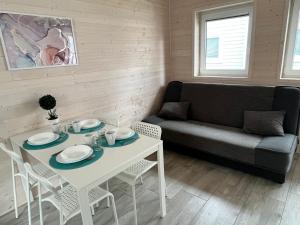 ein Wohnzimmer mit einem Tisch und einem Sofa in der Unterkunft Domki Kalmar Sarbinowo in Sarbinowo