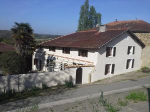 une maison blanche avec un toit rouge dans l'établissement Maison d'hôtes Brameloup Jardin Ovale, à Coudures