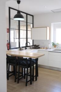 uma cozinha com uma mesa de madeira e cadeiras pretas em AOVE Suite em Jaén