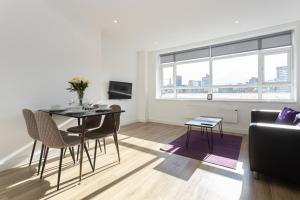 a living room with a table and chairs and a couch at Pillo Rooms Serviced Apartments - Manchester Arena in Manchester