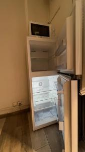 an empty refrigerator with its door open in a kitchen at Studio près de la mer in Port-Vendres