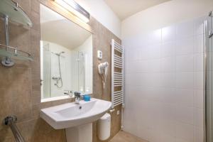 ein weißes Badezimmer mit einem Waschbecken und einem Spiegel in der Unterkunft Academy Pension in Budapest