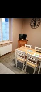 une salle à manger avec une table, des chaises et une horloge dans l'établissement Villa de la dore, à Le Mont-Dore