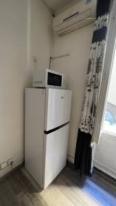 eine Mikrowelle auf einem Kühlschrank im Zimmer in der Unterkunft Studio près de la mer in Port-Vendres