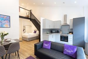 a living room with a couch and a kitchen at Pillo Rooms Serviced Apartments - Manchester Arena in Manchester
