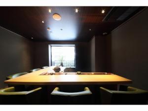 una mesa en una habitación con sillas y una ventana en HOTEL SHIKISAI KYOTO - Vacation STAY 74839v, en Kioto
