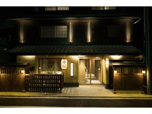 un edificio con un cartel en la parte delantera de la noche en HOTEL SHIKISAI KYOTO - Vacation STAY 74839v, en Kioto