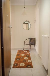 a hallway with a rug and a chair and a mirror at SAVVAS in Nea Plagia