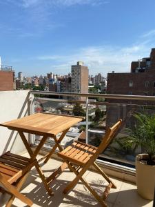 - Balcón con mesa de madera y 2 sillas en Departamento luminoso en Rosario - cochera privada en Rosario