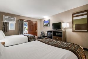Una habitación de hotel con dos camas y un televisor de pantalla plana. en Heritage Inn - Yosemite/Sonora, en Sonora