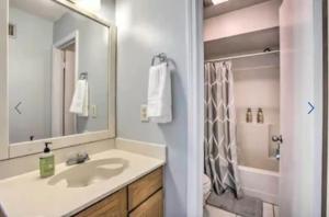 uma casa de banho com um lavatório, um WC e um espelho. em New! LSU Baton Rouge Contemporary 3 Bedroom Suite Condo em Baton Rouge