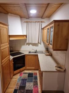 a small kitchen with wooden cabinets and a sink at Bolfenk Snowflake app in Hočko Pohorje