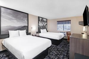 um quarto de hotel com duas camas e uma televisão de ecrã plano em Super 8 by Wyndham Charlottesville em Charlottesville