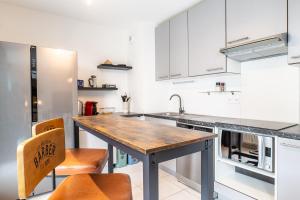 a kitchen with white cabinets and a wooden counter top at Annecy Lake Central in Annecy