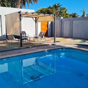uma piscina com cadeiras e um guarda-sol em 51 On Vlei em Cidade do Cabo