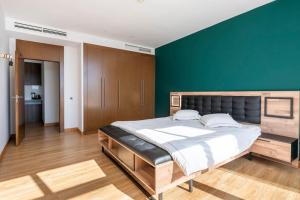 une chambre avec un grand lit et un mur végétal dans l'établissement Luxury Apartment Hilton 5*, à Tanger