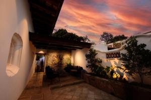 een gebouw met een zonsondergang op de achtergrond bij Villa Las Mil Flores in Antigua Guatemala