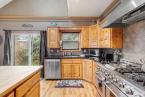 a kitchen with wooden cabinets and a stove top oven at Once Upon a Tide in Lincoln City
