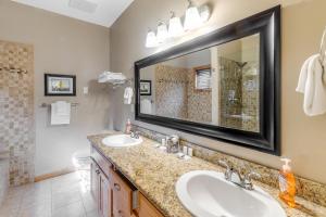 a bathroom with two sinks and a large mirror at Once Upon a Tide in Lincoln City