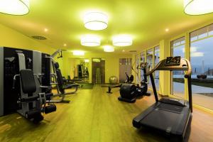 einen Fitnessraum mit Laufbändern und Crosstrainern in einem Zimmer in der Unterkunft Wellnesshotel Oswald in Kaikenried