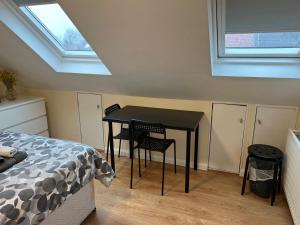 1 dormitorio con mesa negra, sillas y ventana en Kensal Lodge 2 Guest House en Londres