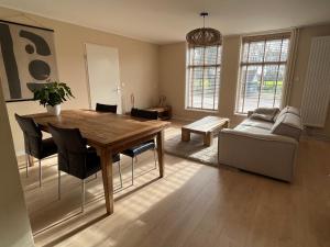 フラウウェンポルデルにあるDorpsdijk 49, Vrouwenpolder vakantieの木製のテーブルとソファのあるリビングルーム