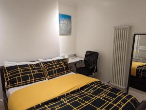 a bedroom with a bed and a desk and a chair at Fully-equipped flat in the city of London. in London