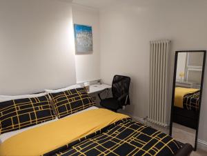 um quarto com uma cama, uma cadeira e um espelho em Fully-equipped flat in the city of London. em Londres