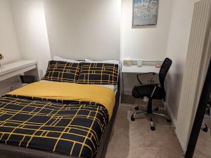 a bedroom with a bed and a desk and a chair at Fully-equipped flat in the city of London. in London