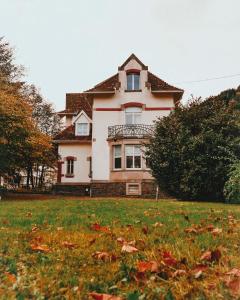 a large house in a field with leaves in the grass at La Maison du Markstein in Linthal