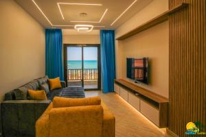 a living room with a couch and a tv at SeaView Turtles in Hurghada