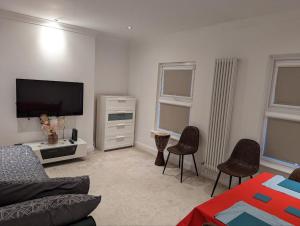 a living room with a couch and a flat screen tv at Fully-equipped flat in the city of London. in London