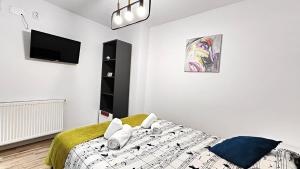 a bedroom with a bed and a flat screen tv at Grand Central Studios in Sibiu