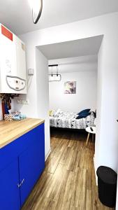 a kitchen with blue cabinets and a bedroom with a bed at Grand Central Studios in Sibiu