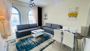 a living room with a blue couch and a table at Newly furnished cozy ONE bed room Apartment 2 bathroom city view in Dubai