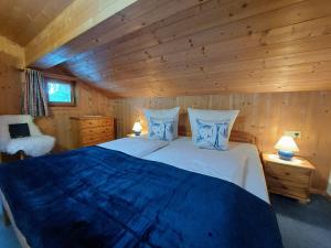 a bedroom with a bed in a log cabin at Bergmomente Montafon Ferienhaus Bitschweil in Tschagguns