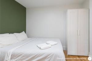 a bedroom with a white bed with two towels on it at West Broadway Quarters by Thatch in Boston